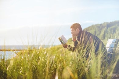 Man reading a book in the field