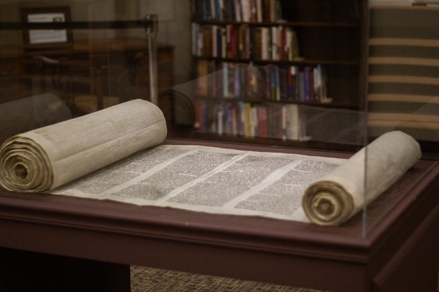  An open Hebrew megillah scroll on a table