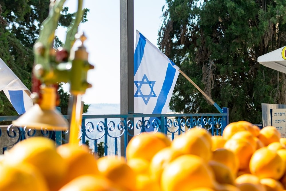A fruit vendor’s cart with Israeli flag in the background