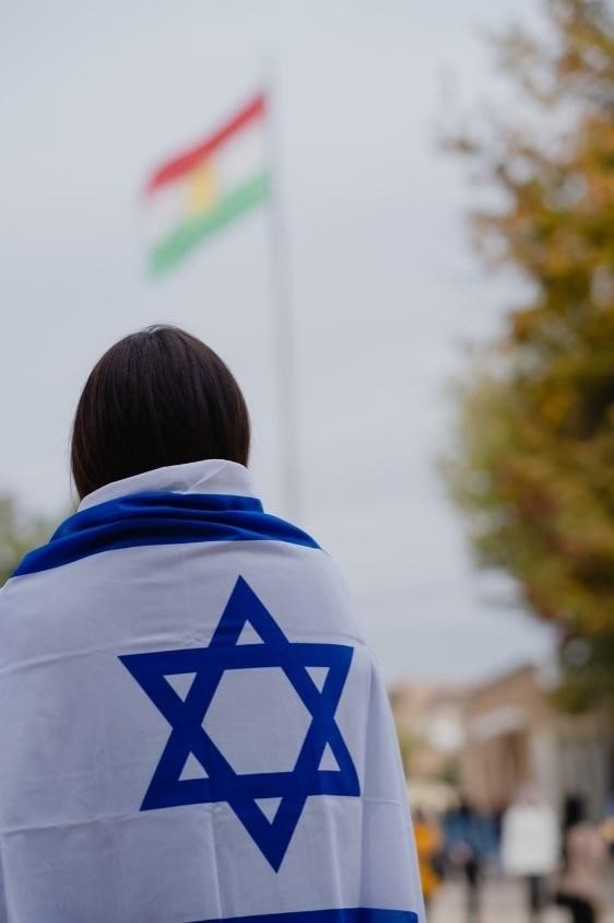 A person with an Israeli flag wrapped around his back