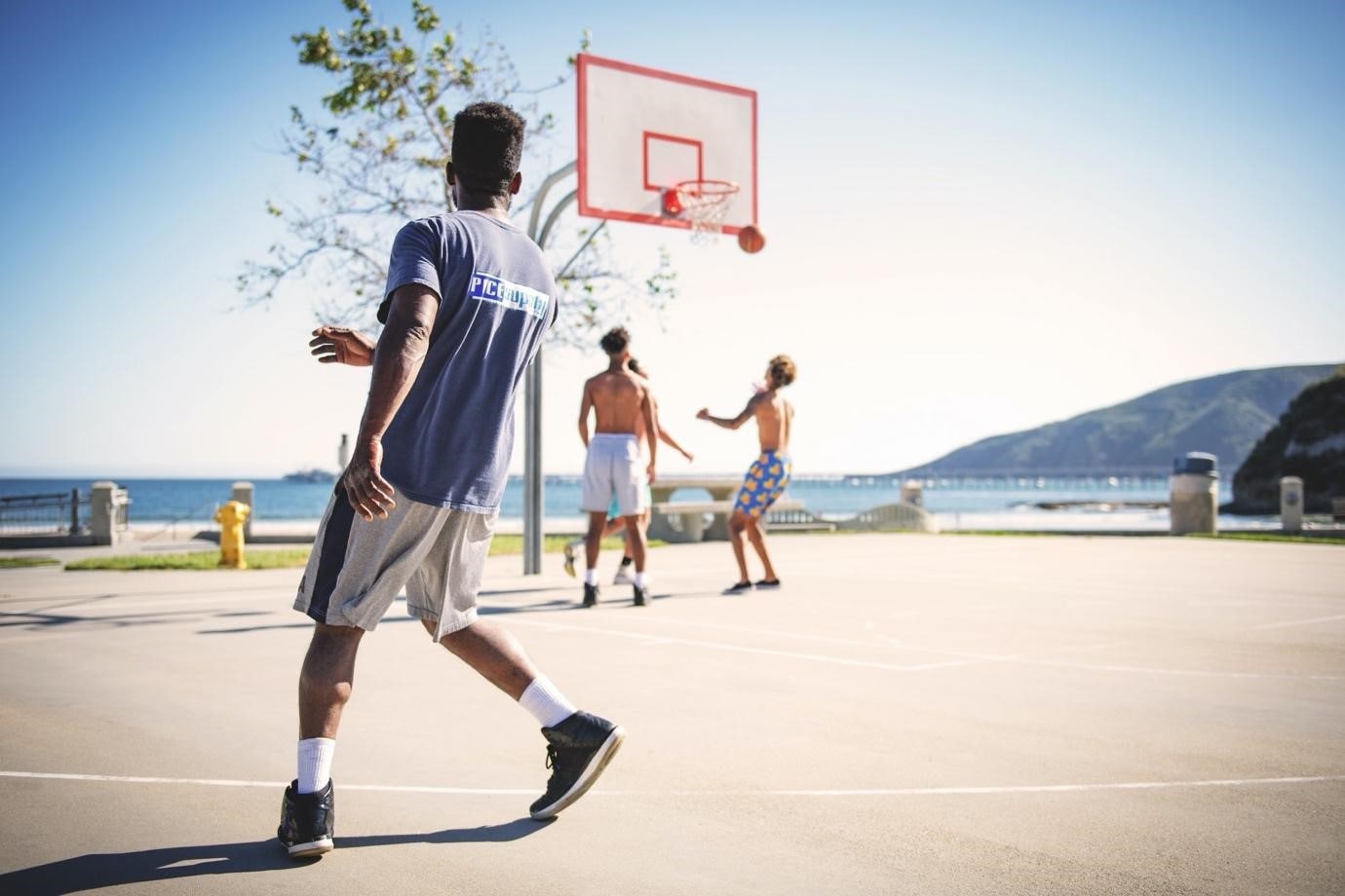 people playing basketball on an outdoor court