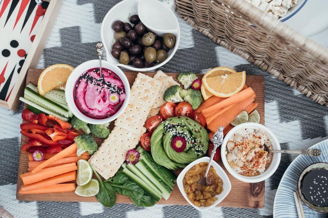 A fruit and vegetable platter with a bowl of hummus